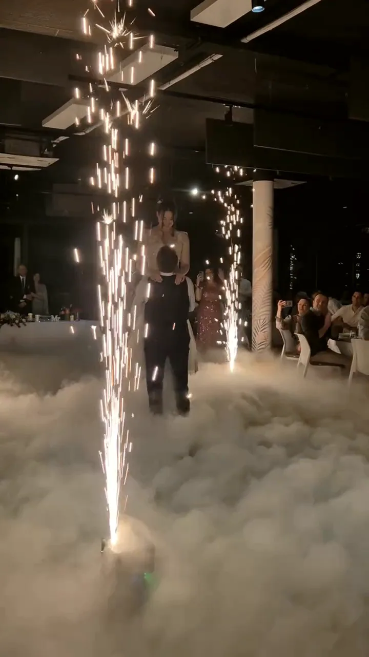 Fontana prskalica uzdiže se iz niskog dima dok mladenci plešu