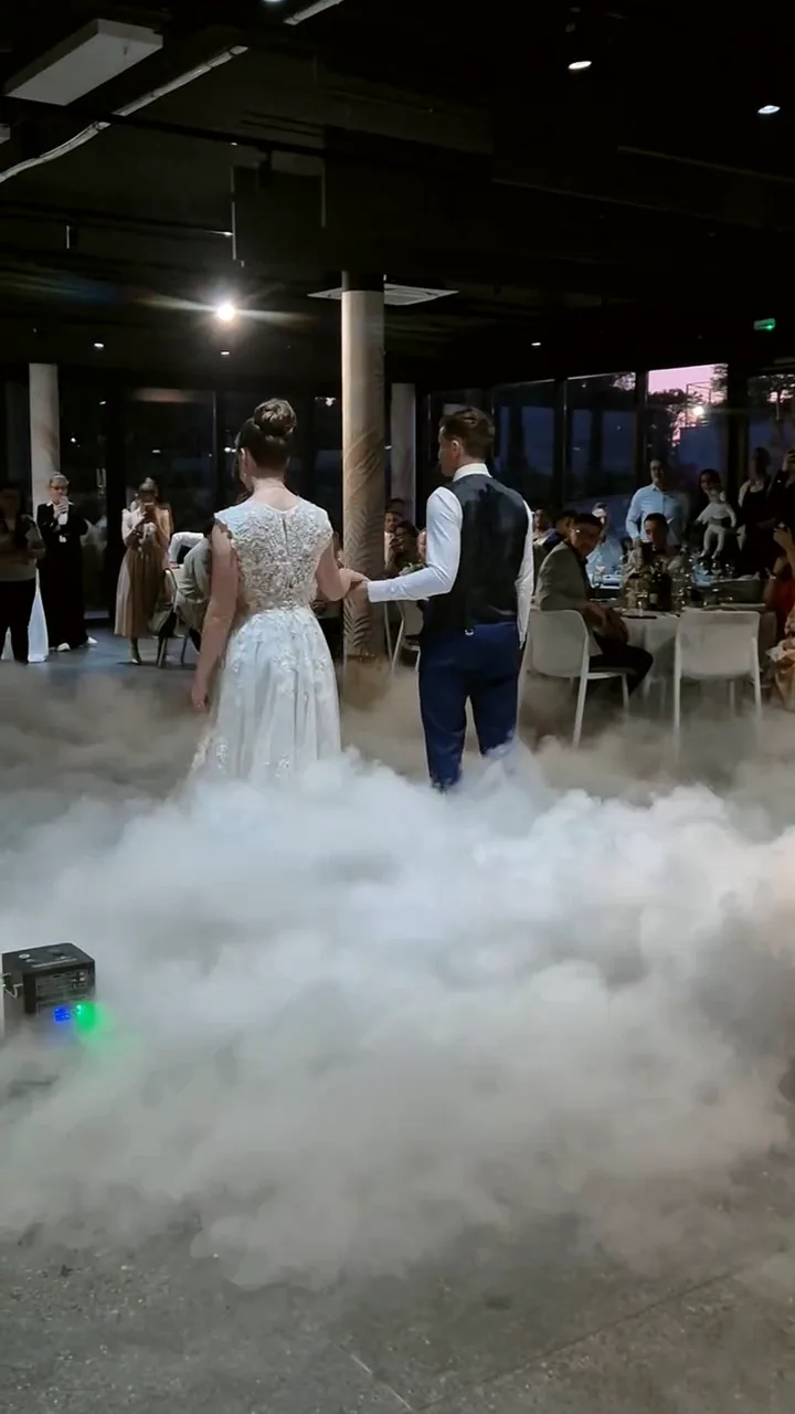 Mladenci drže se za ruke u gustom niskom dimu na plesnom podiju